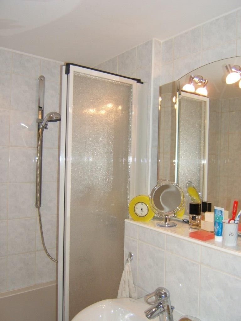 Ein Badezimmer mit Waschbecken, Spiegel und Dusche