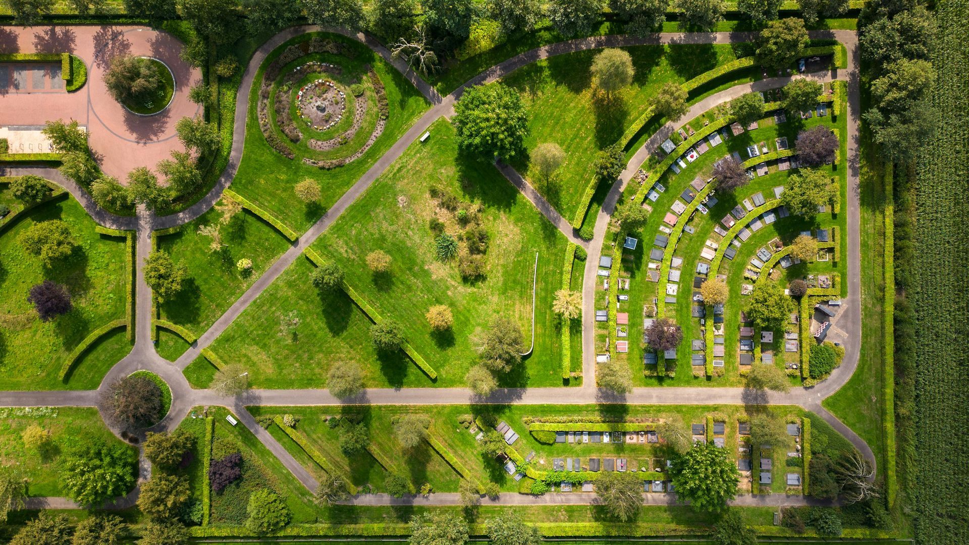 Una vista aérea de un cementerio rodeado de árboles y césped.
