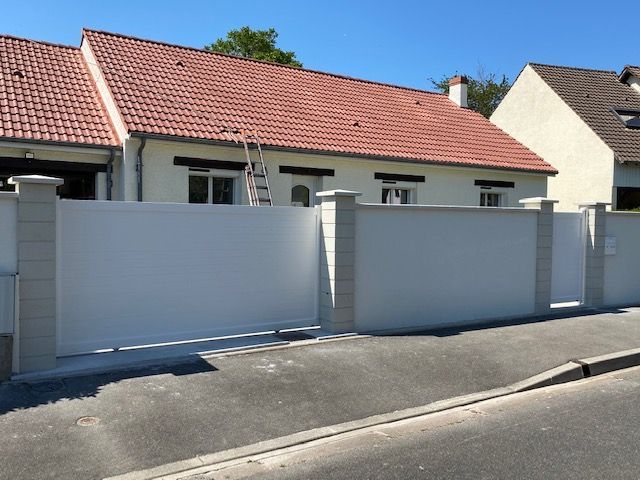 Portail blanc devant un pavillon.