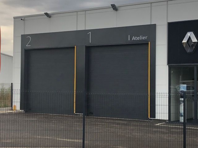 Deux volets gris roulants de garage professionnel.