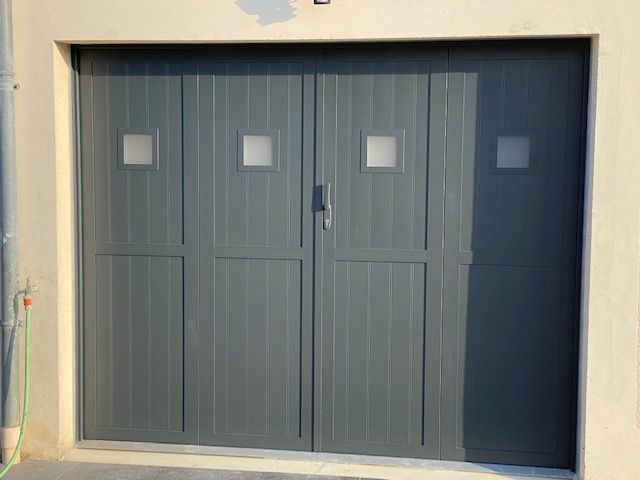 Une porte de garage grise à ouverture en accordéon.