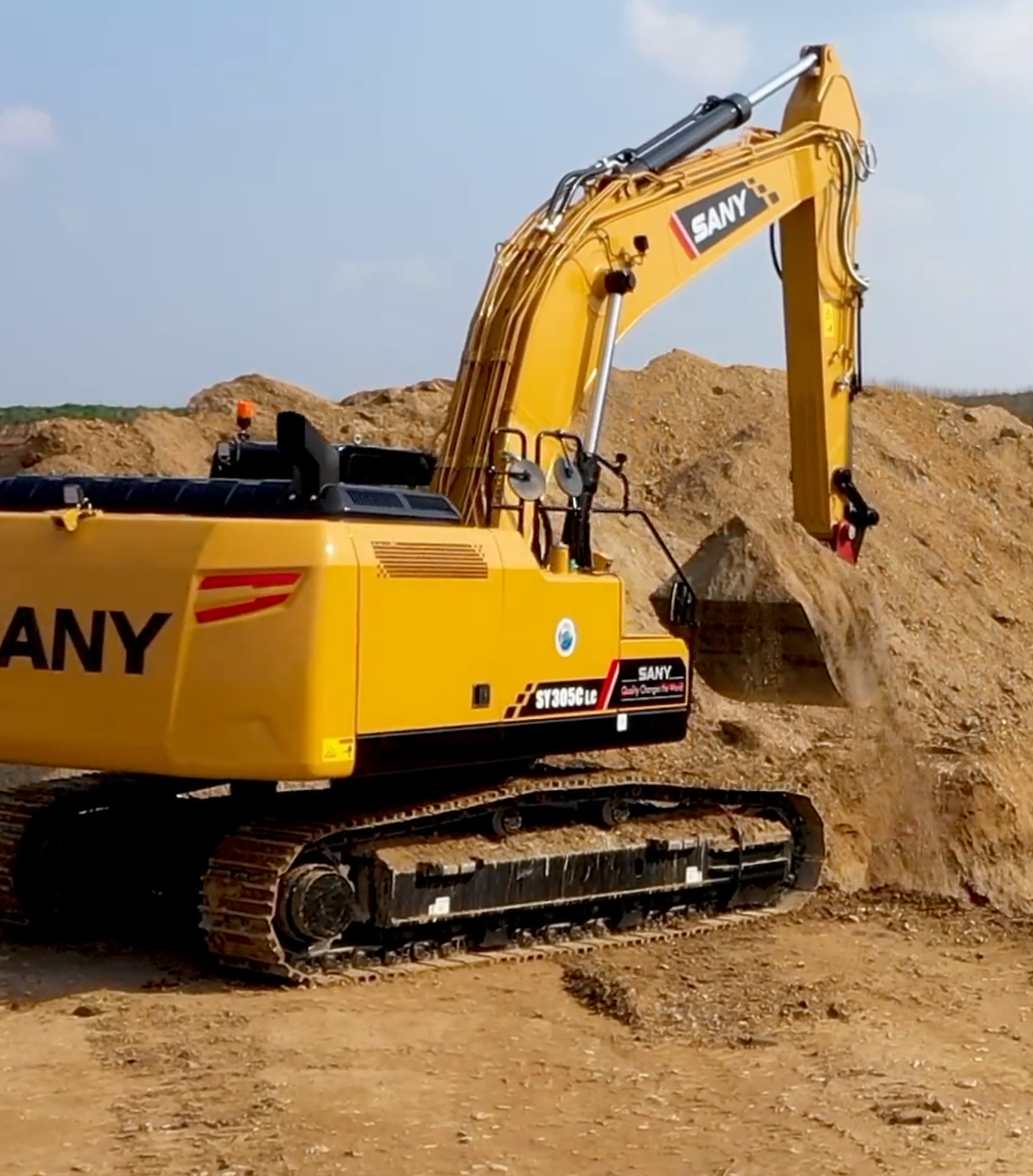 Une petite excavatrice creuse un tas de terre, préparant un chantier de construction.