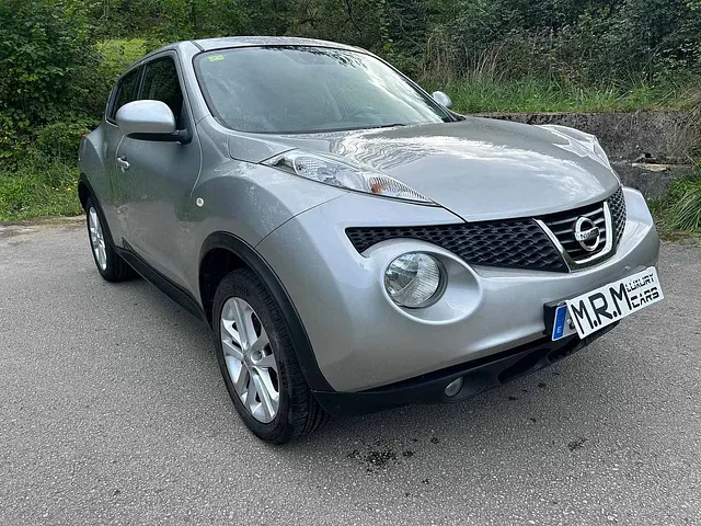 Un Nissan Juke plateado está estacionado al costado de la carretera.