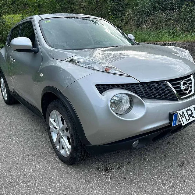 Un Nissan Juke plateado está estacionado al costado de la carretera.