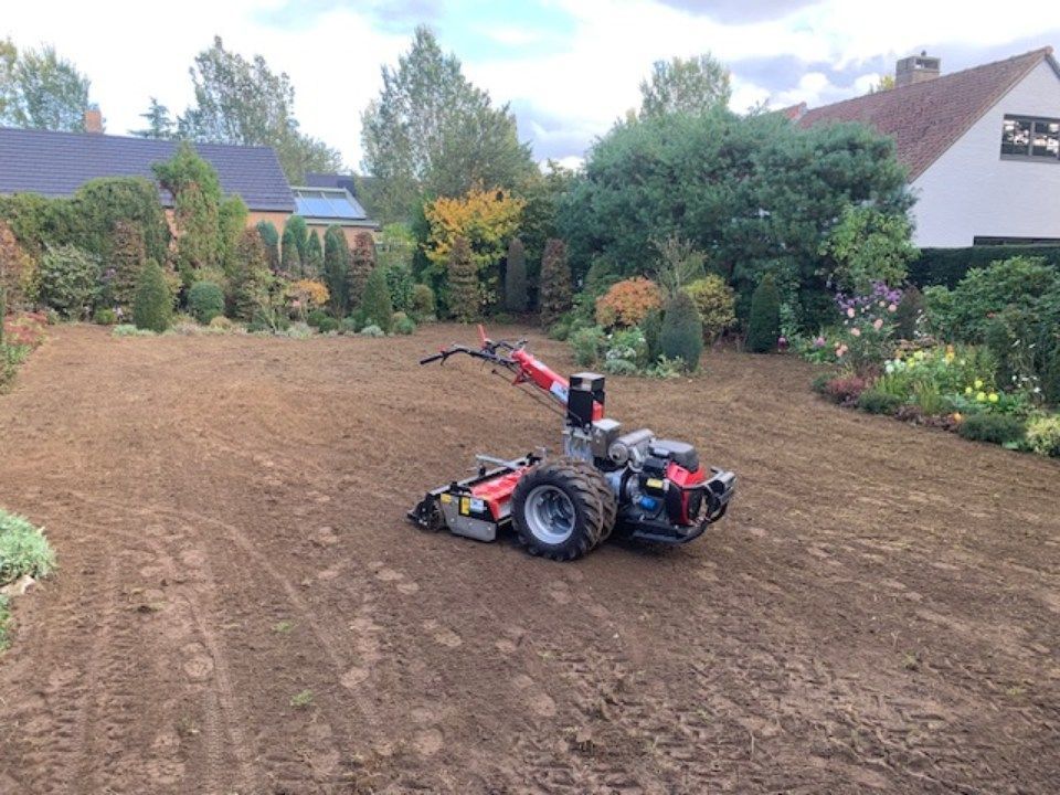 een man aan het werk op een kleine tuintractor