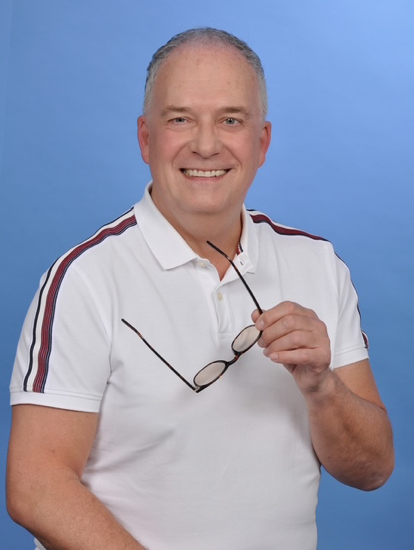 Ein Mann in einem weißen Hemd hält eine Brille