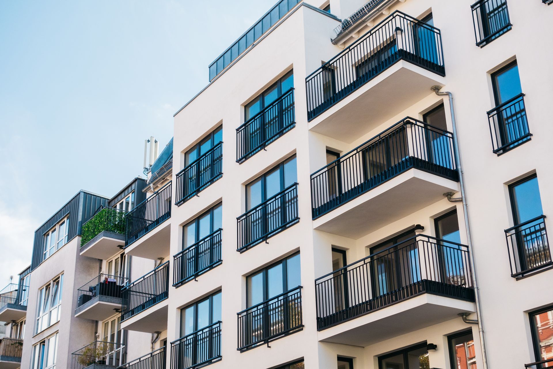 Immeubles d'appartements modernes blancs avec balcons se détachant sur un ciel bleu