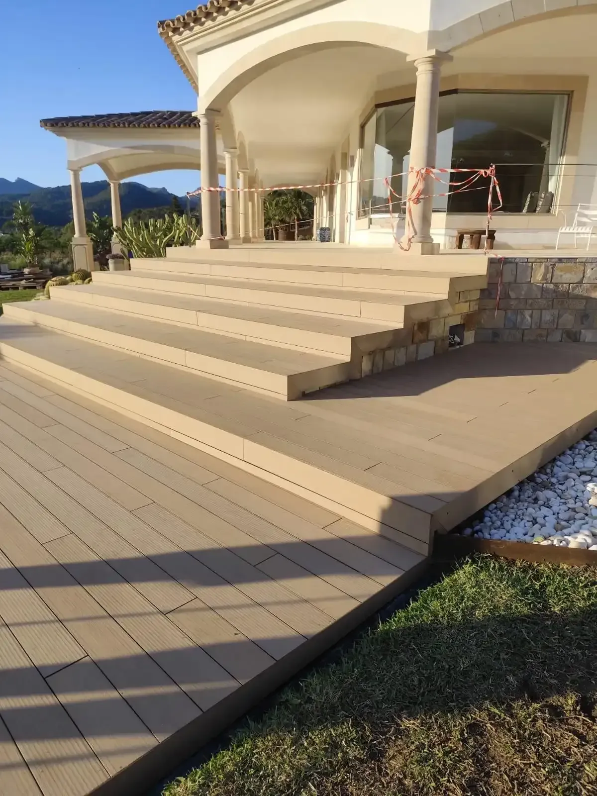 Amplias escaleras de piedra conducen a una villa moderna con columnas 