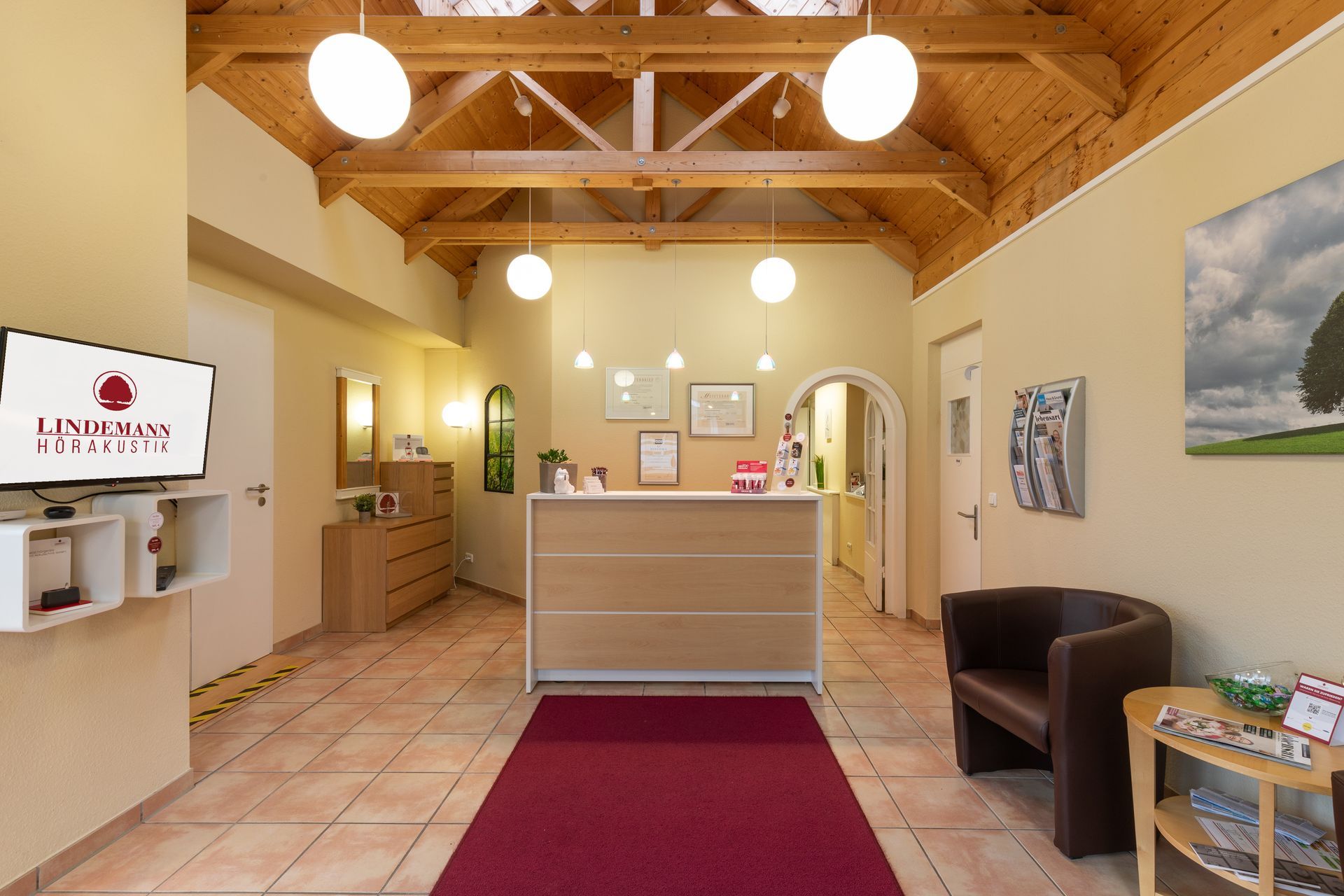 Ein Wartezimmer mit rotem Teppich und einem Holzschreibtisch.