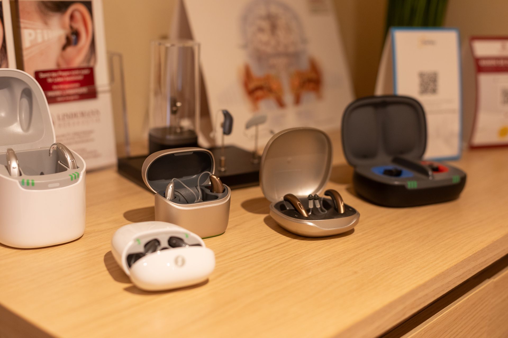 Auf dem Tisch liegen viele verschiedene Hörgerätetypen.