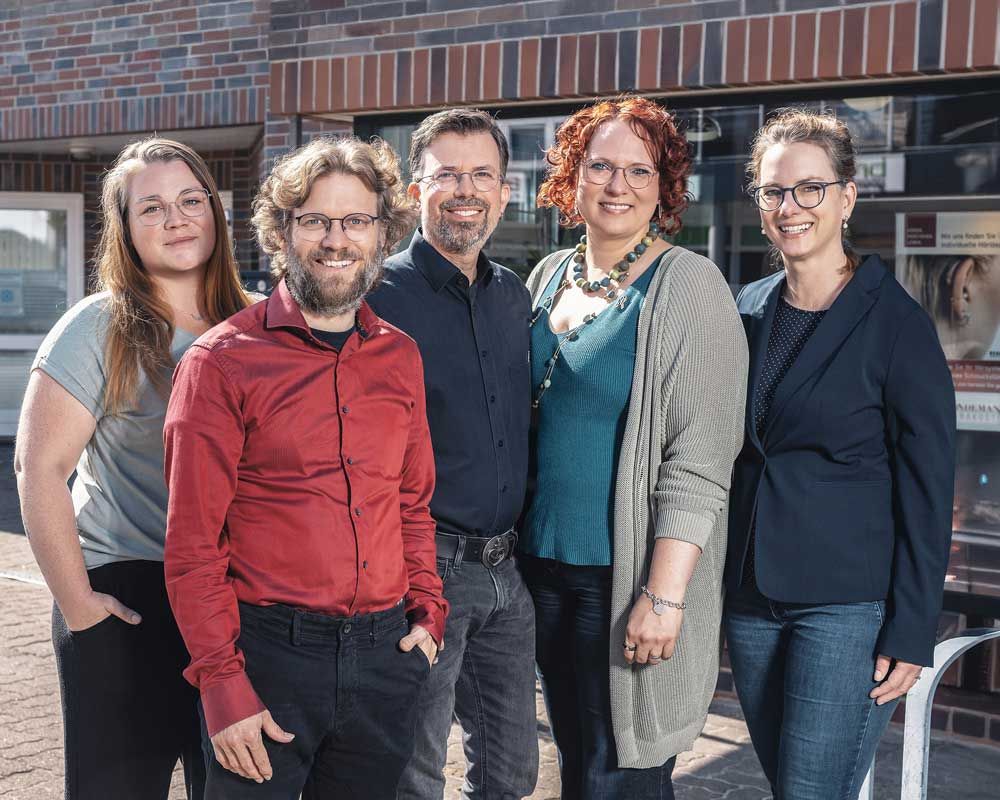 Eine Gruppe von Menschen mit Brillen posiert für ein Foto.