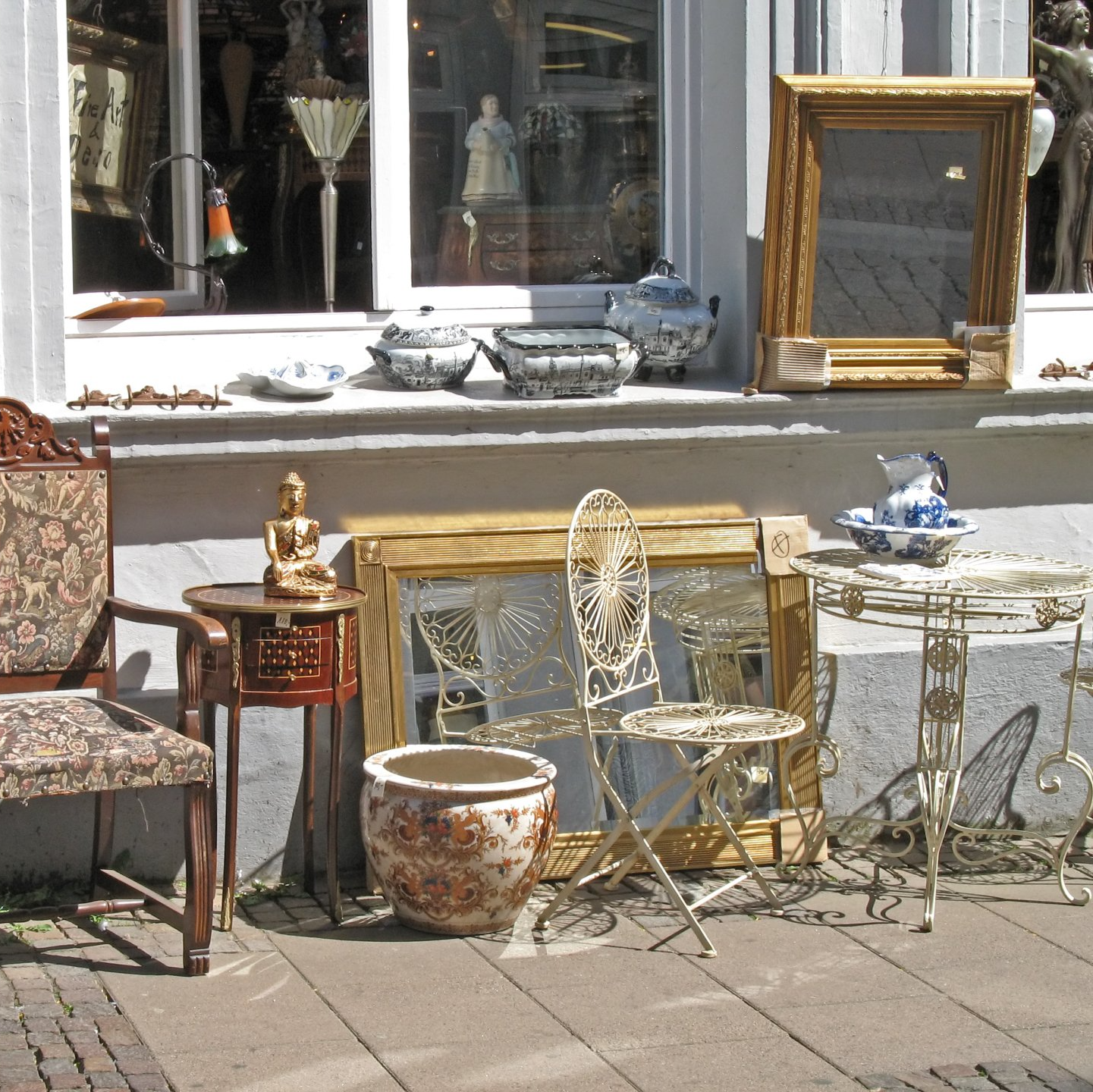 Fauteil ancien, ensemble de chaise et de table sur un trottoir au soleil