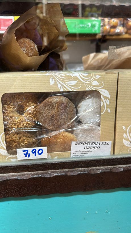 Una caja de donas está sobre el mostrador de una panadería.
