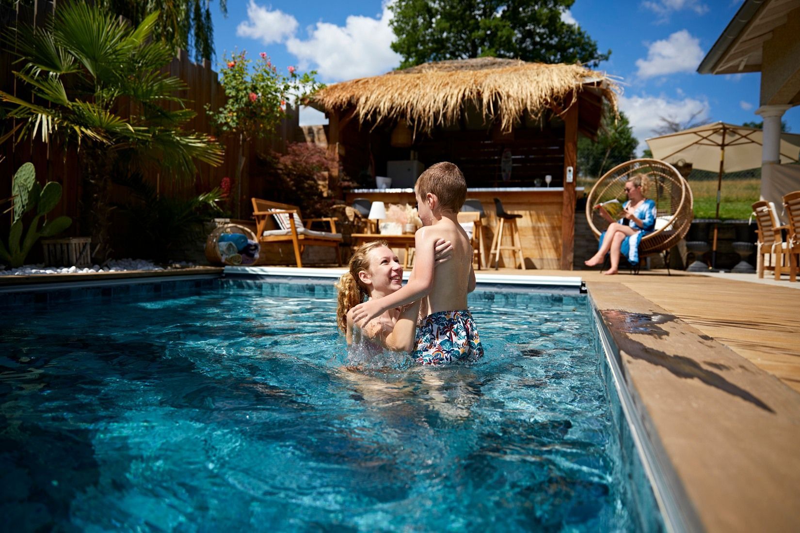 Femme dans une piscine tenant un enfant dans ses mains