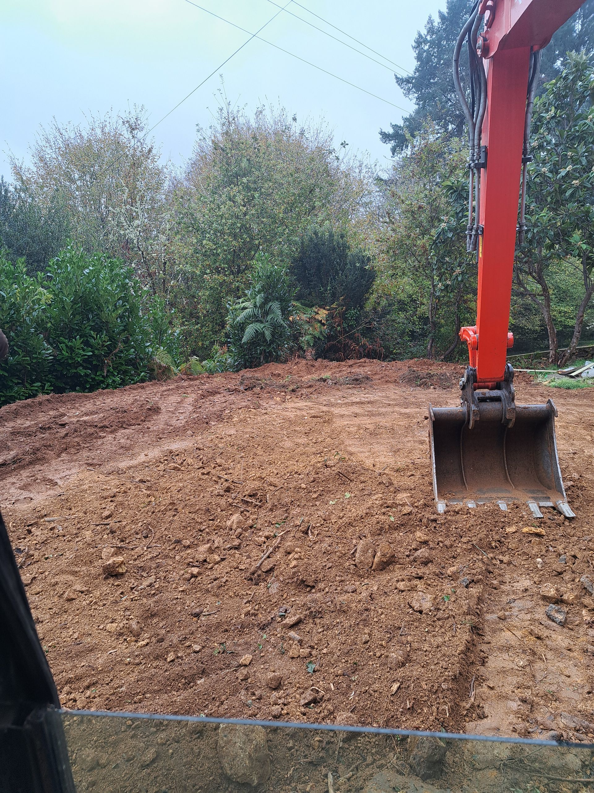 Une pelleteuse en train d'aplanir un terrain.