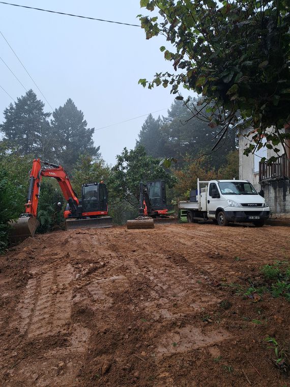 Deux minipelles rouges et un camion blanc sur un terrain.