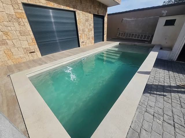 Una gran piscina frente a una casa