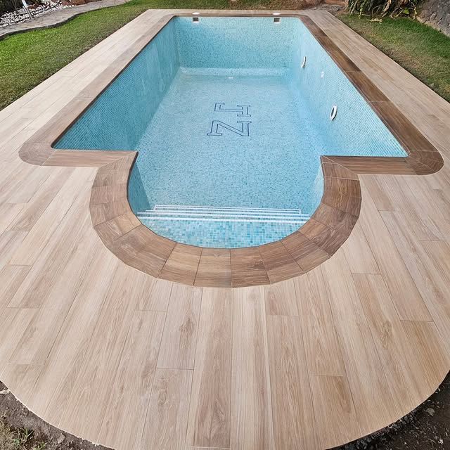 Una piscina vacía con una plataforma de madera alrededor.