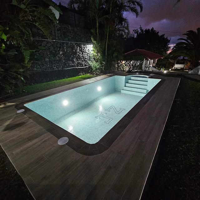 Una gran piscina está iluminada por la noche