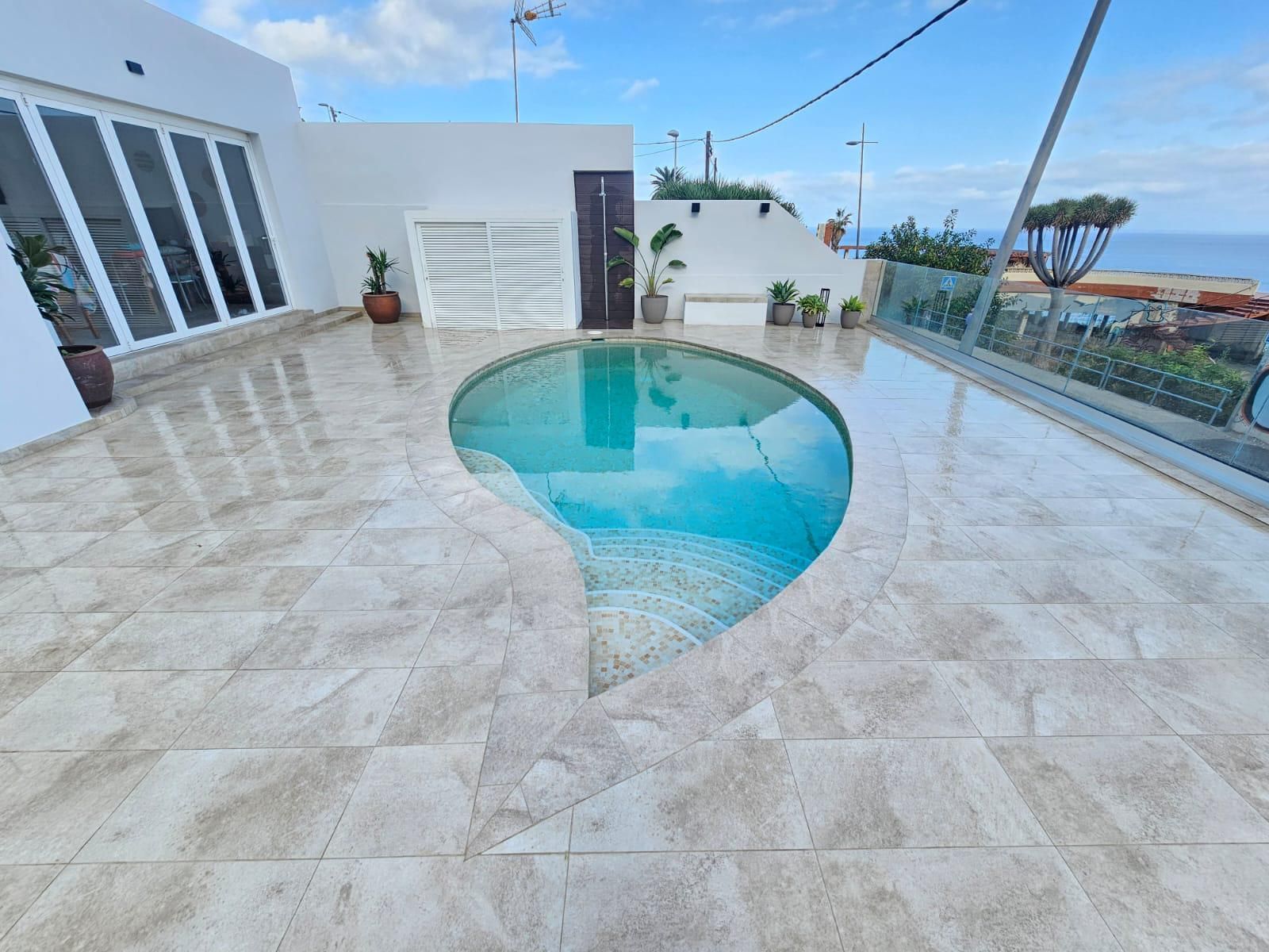 Una gran piscina en medio de un suelo de baldosas.