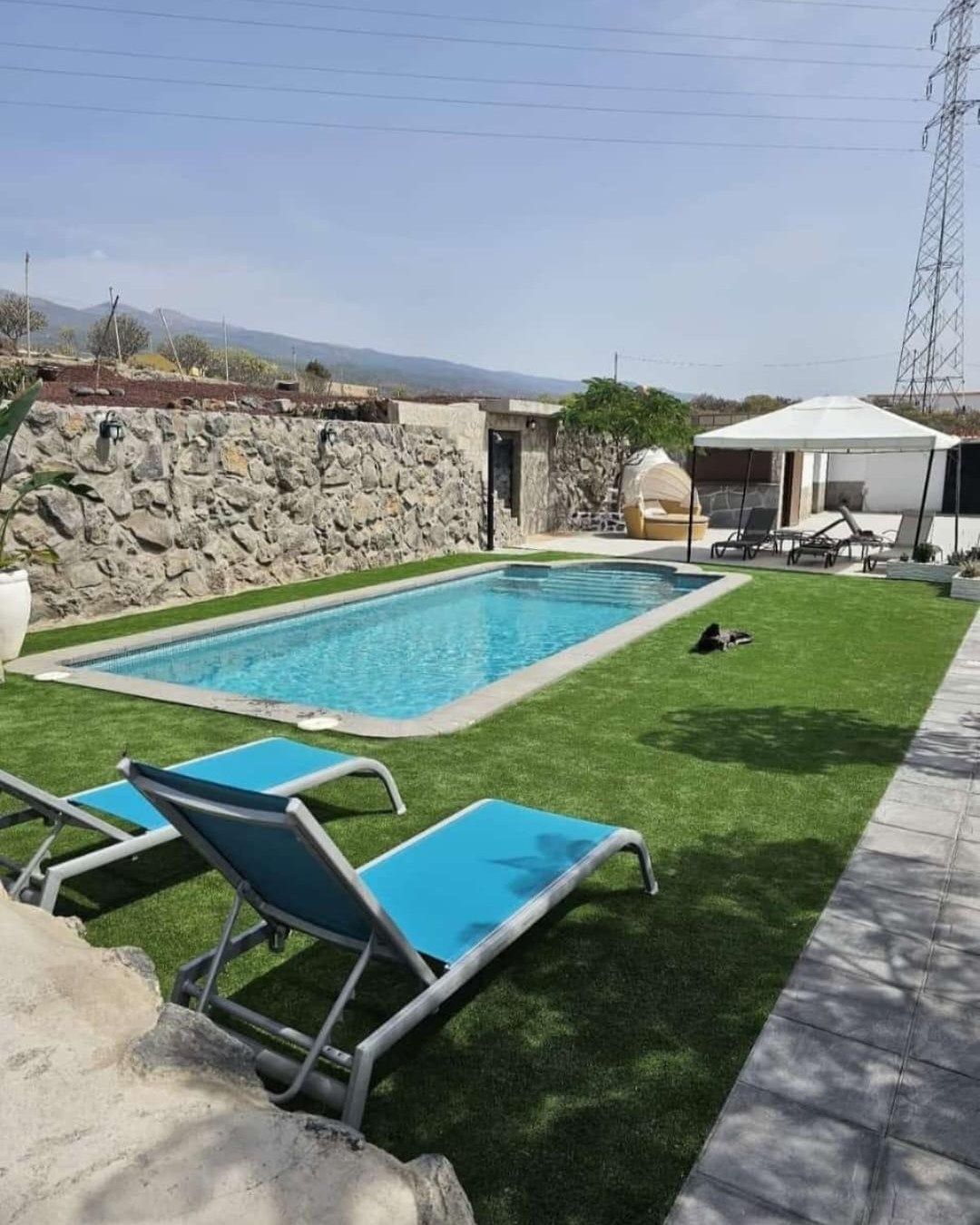 Una gran piscina rodeada de tumbonas y sombrillas.