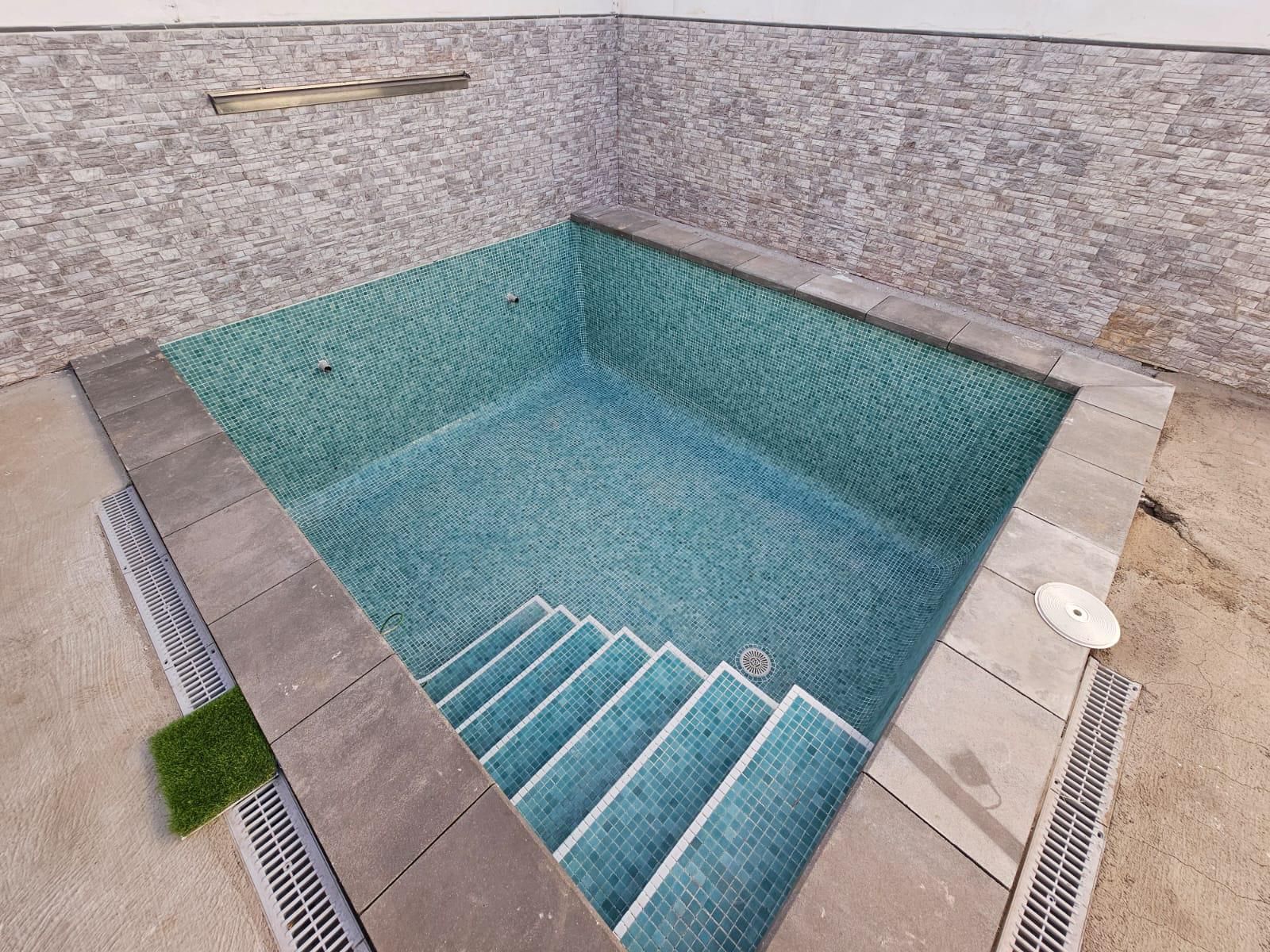 Una pequeña piscina con escaleras que conducen a ella.