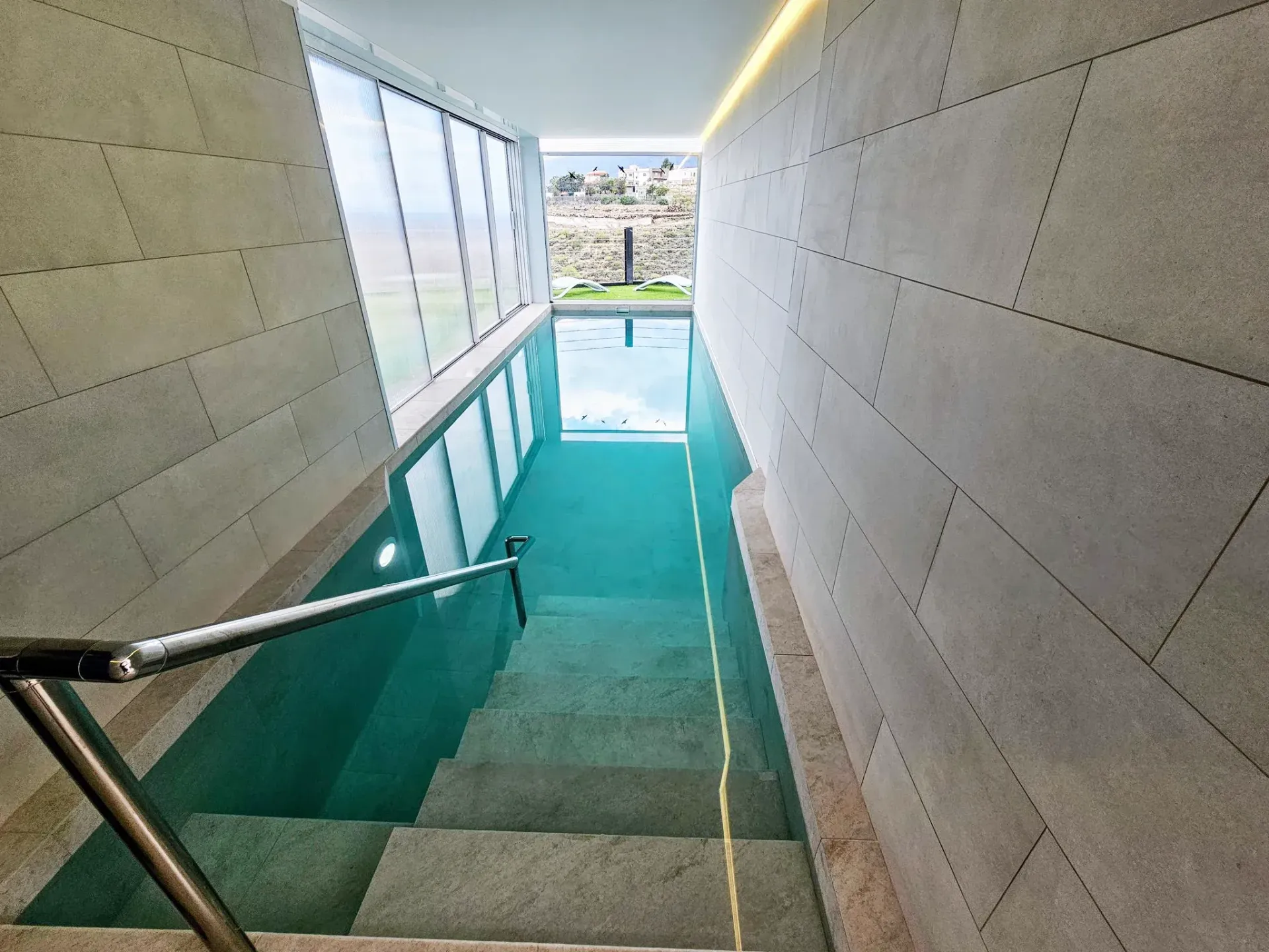 Una escalera que conduce a una gran piscina.
