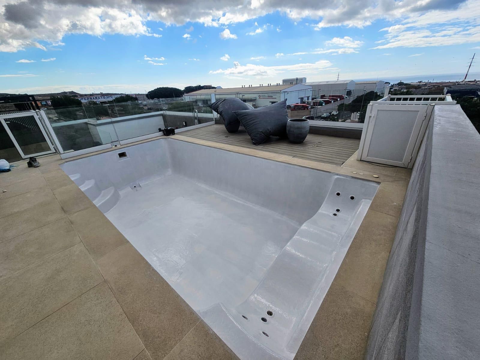 Un rodillo de pintura azul con un mango rojo sobre una superficie blanca