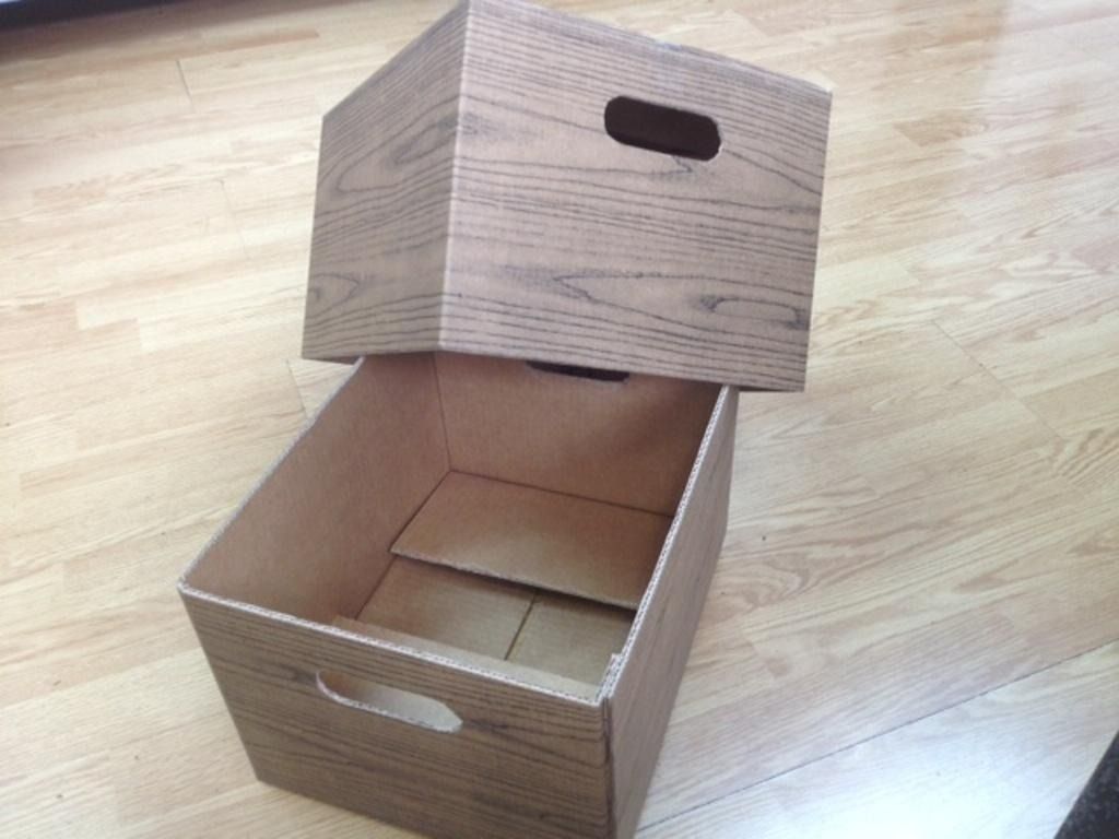 Dos cajas de madera con asas sobre un suelo de madera.