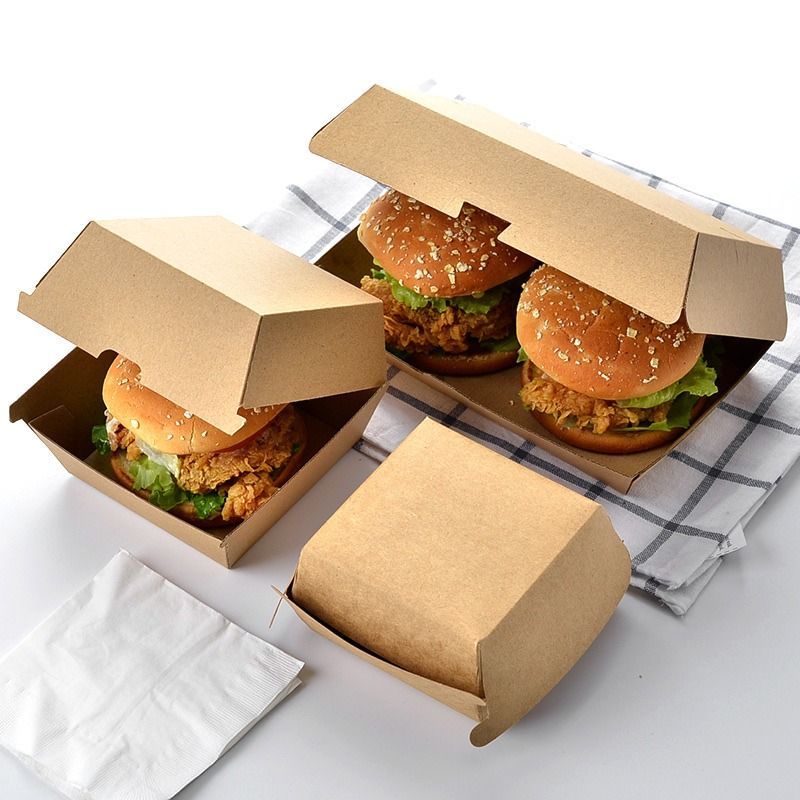 Tres hamburguesas en cajas de cartón sobre una mesa