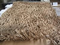 Una pila de cartón triturado se encuentra encima de una mesa de madera.