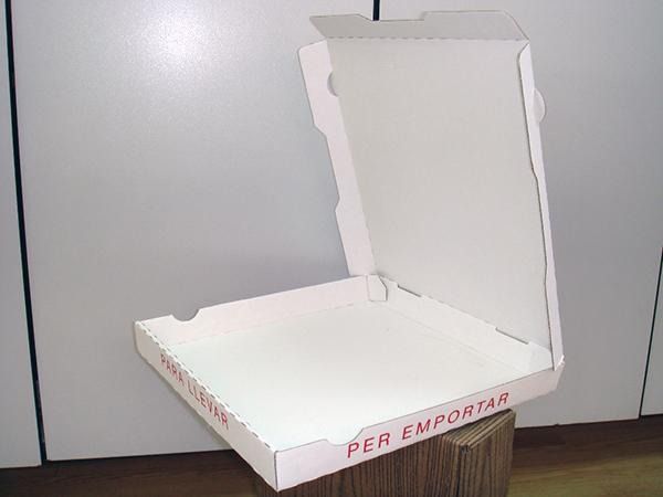 Una caja de pizza vacía está sobre una mesa de madera.