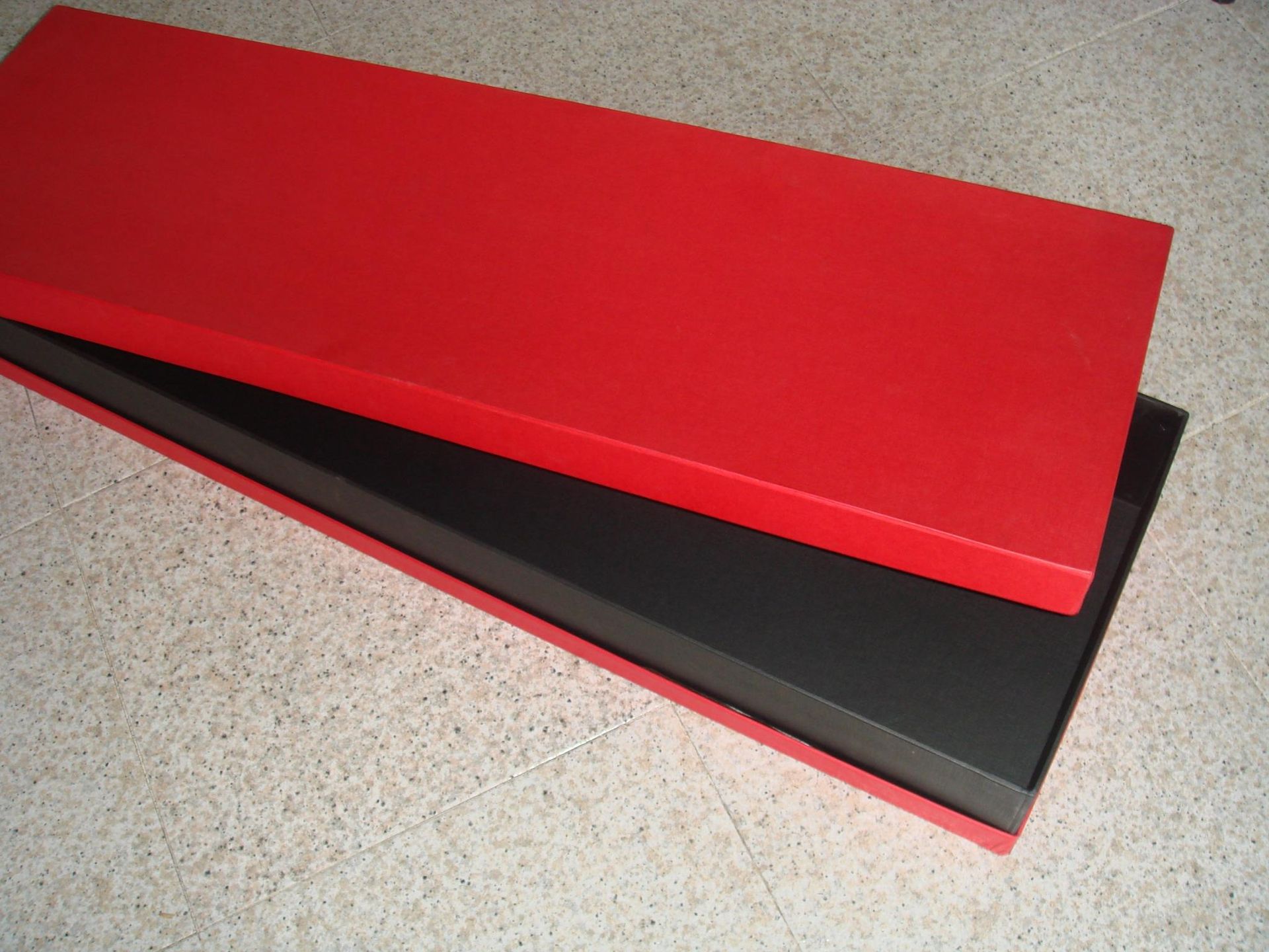 Una caja roja está encima de una caja negra