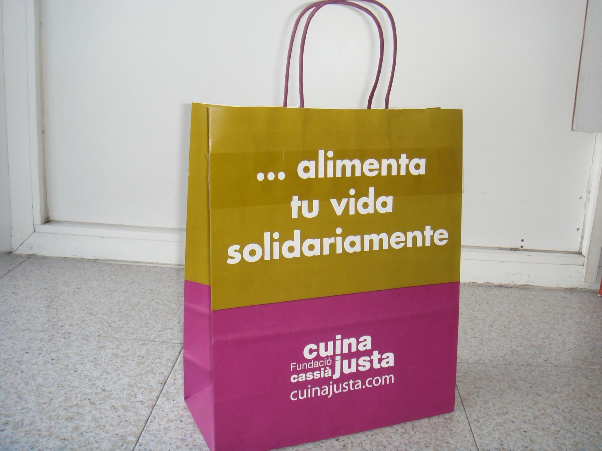 A paper bag that says ' alimenta tu vida solidariamente ' on it