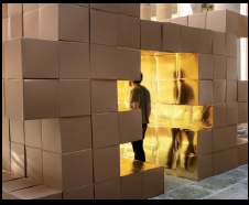 Un hombre está parado en una habitación hecha de cajas de cartón.