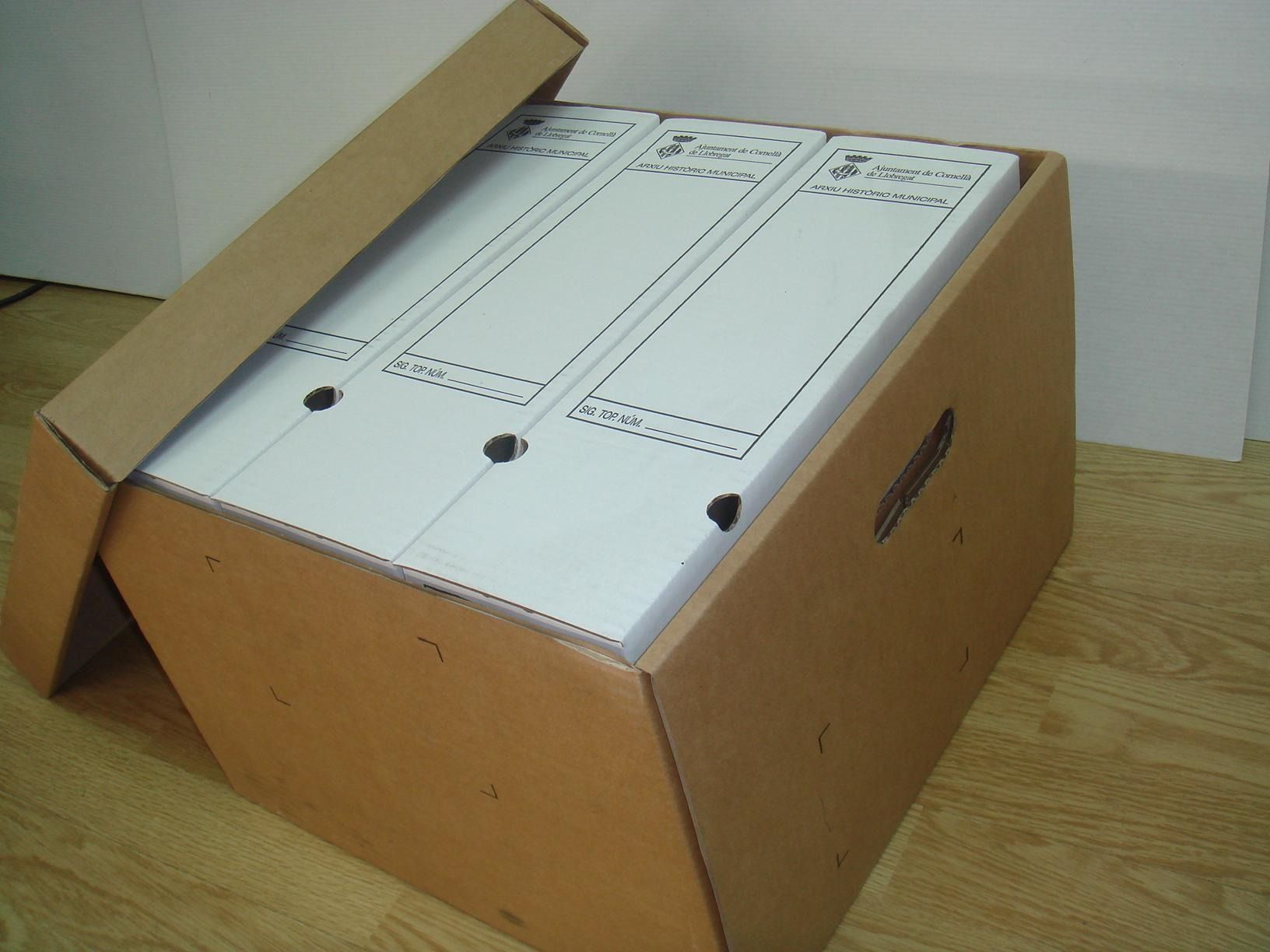 Tres carpetas en una caja de cartón con la tapa abierta