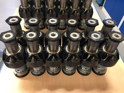 Auf einem Tisch sind mehrere Schrauben und Muttern übereinander gestapelt.