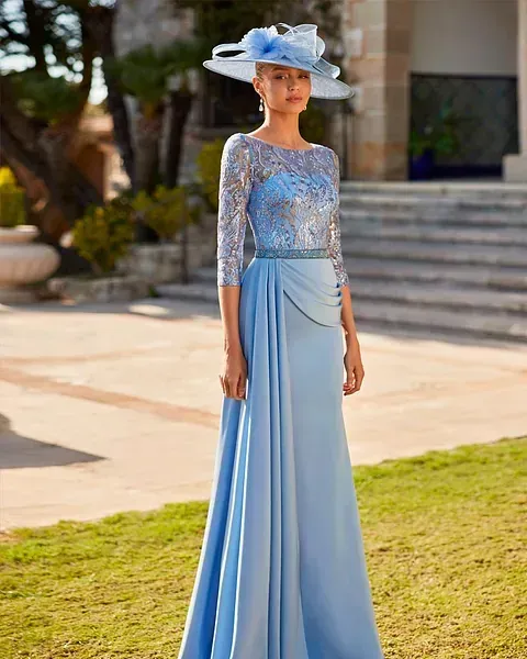 Una mujer lleva un vestido azul claro y un sombrero.