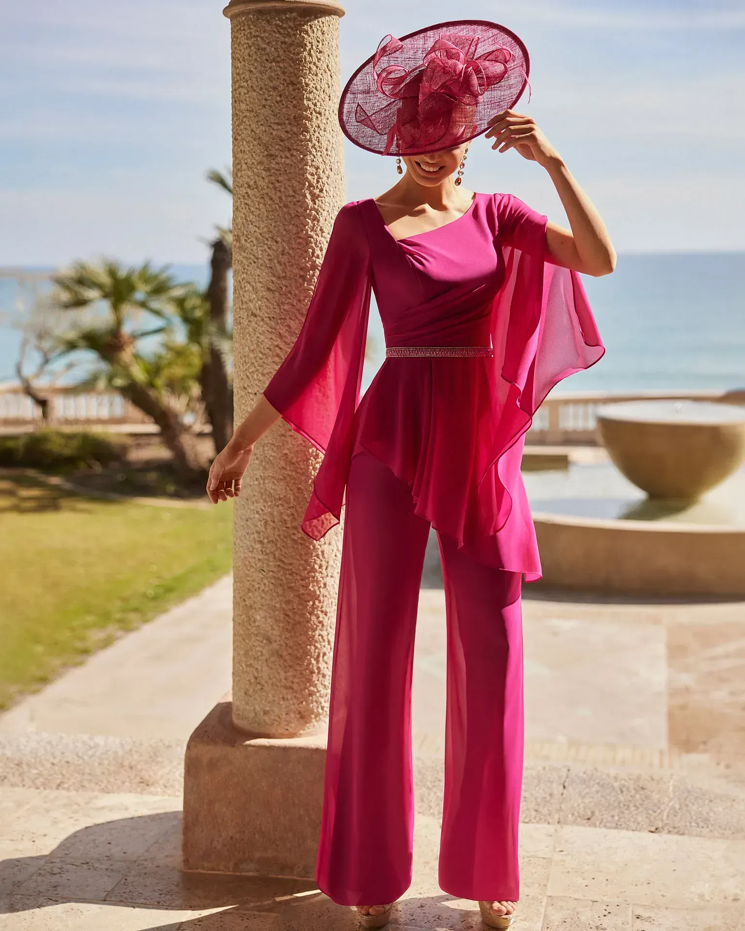 Una mujer que lleva un mono rosa y un sombrero rosa