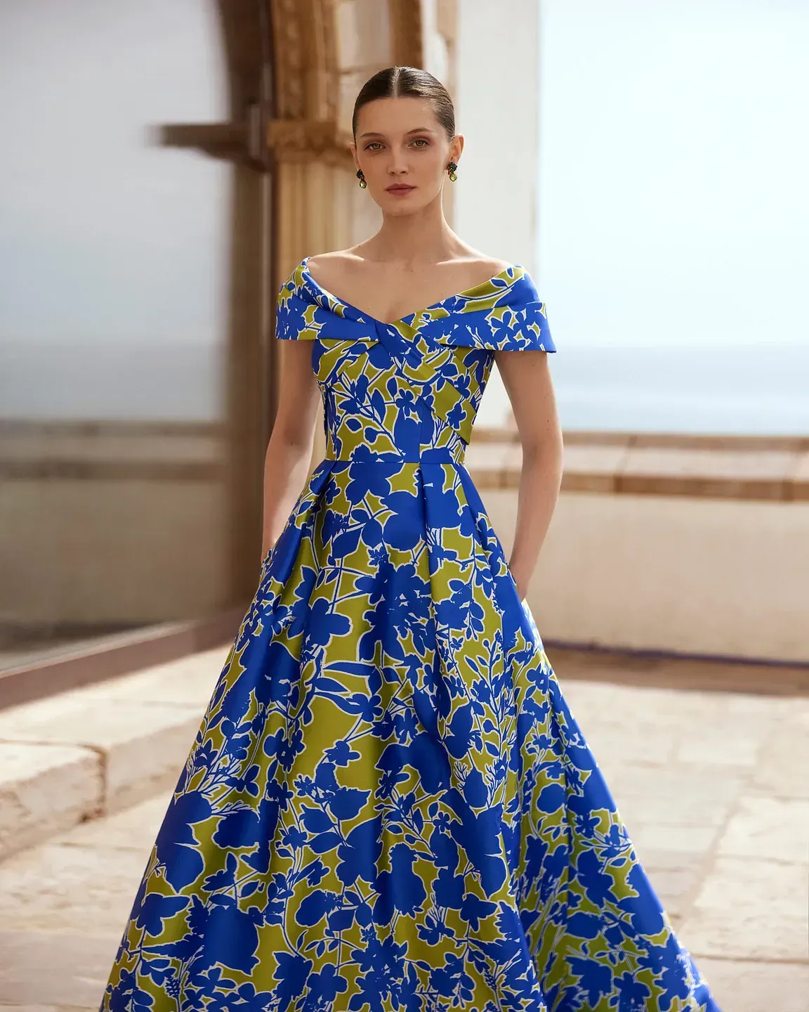 Una mujer lleva un vestido azul y verde.