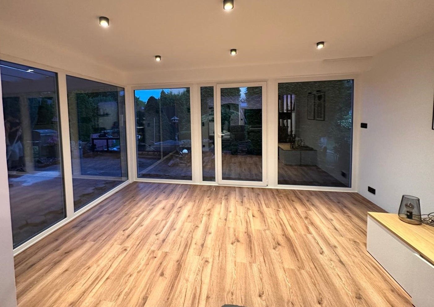 Ein Wohnzimmer mit Hartholzböden und vielen Fenstern