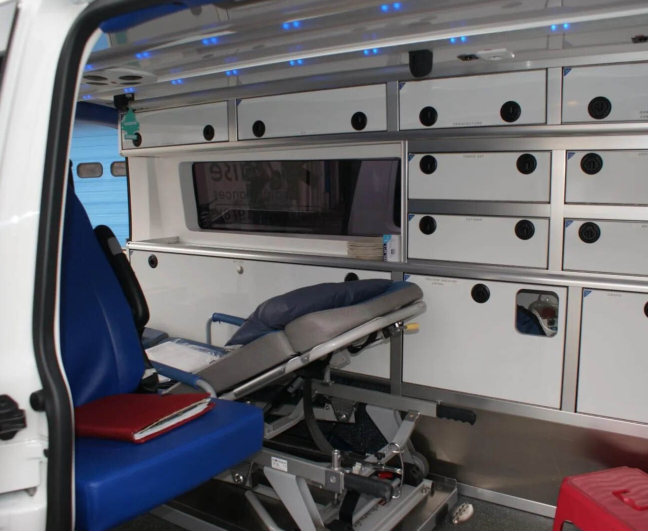 Intérieur de l'ambulance avec une carpette rouge sur un siège