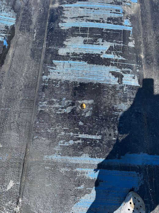 L'eau de pluie ruisselle d'un coin de gouttière de toit gris lors d'une pluie légère.