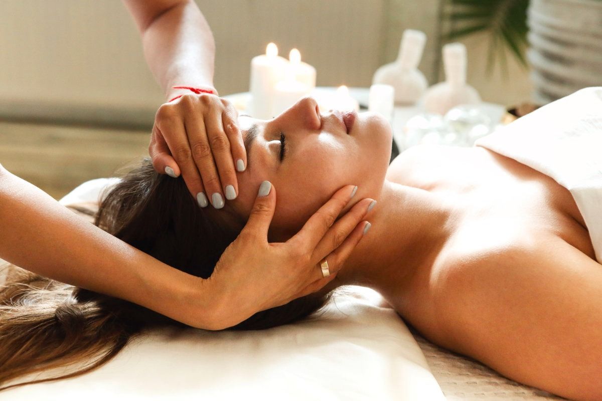 Una mujer está recibiendo un masaje de cabeza en un spa.