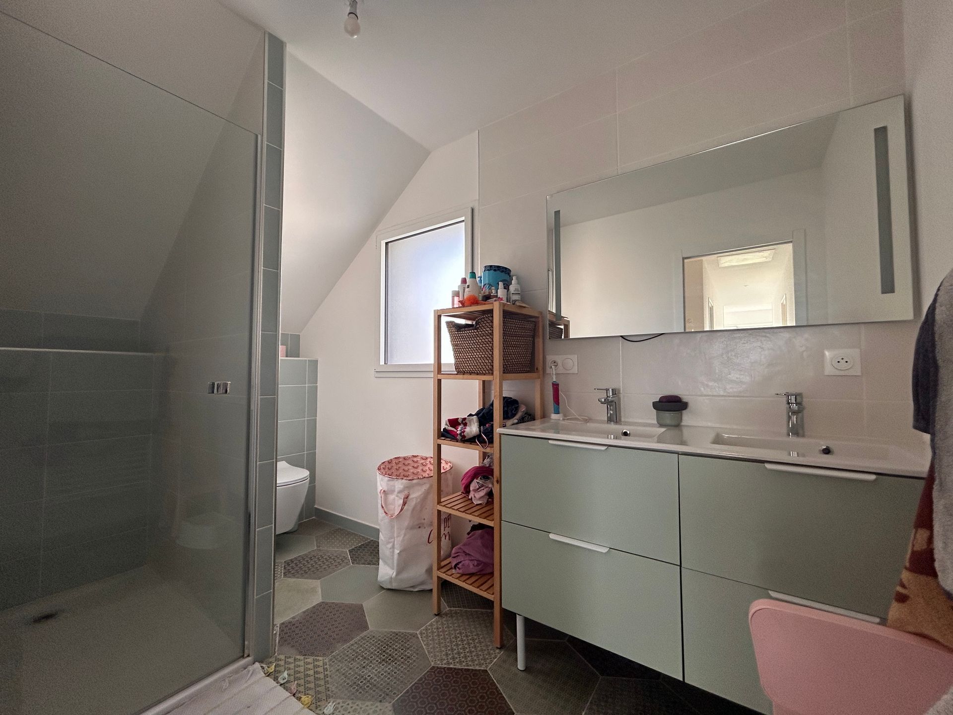 Une salle de bains avec une fenêtre et un miroir rectangulaires