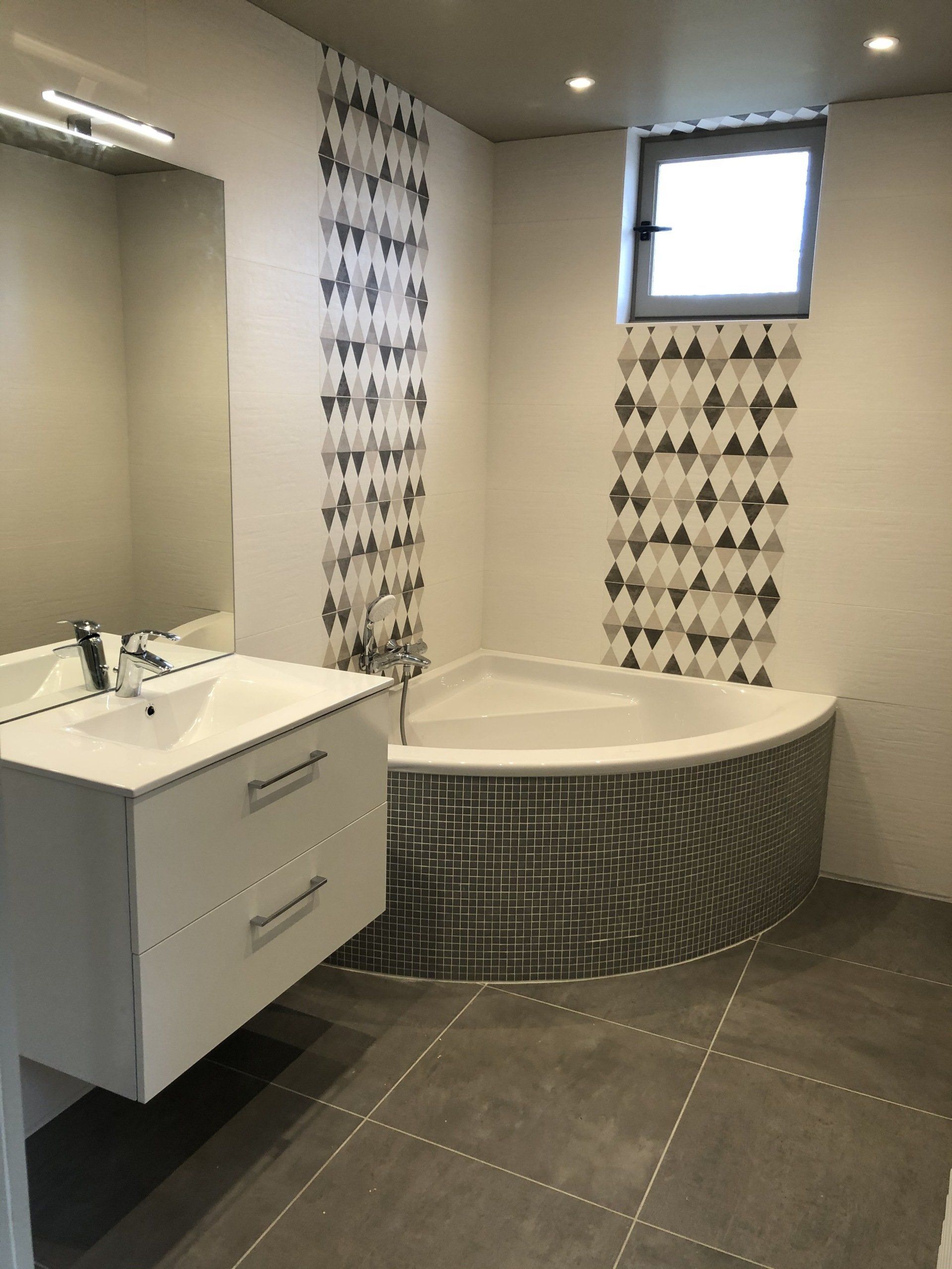 Salle de bains avec meuble vasque et baignoire d'angle