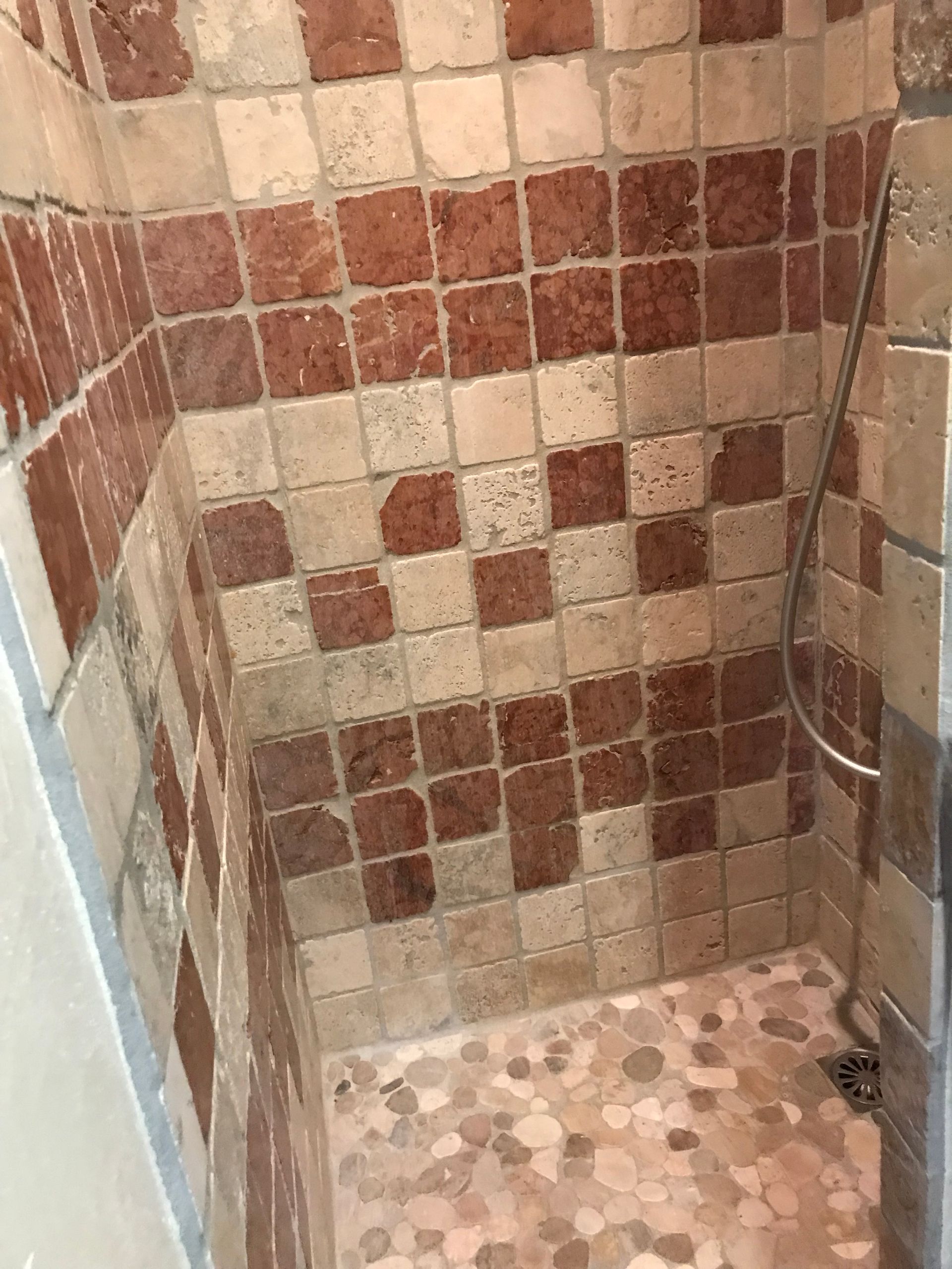 Douche en travertin vieilli et rouge de Verone, receveur en galets sciés
Le Vésinet