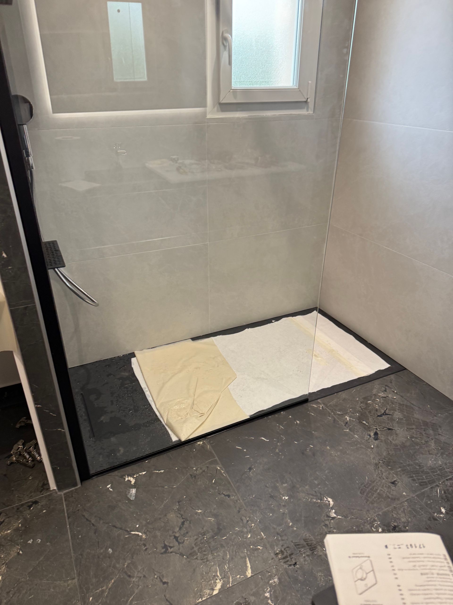 Receveur de douche en cours de pose, murs clairs