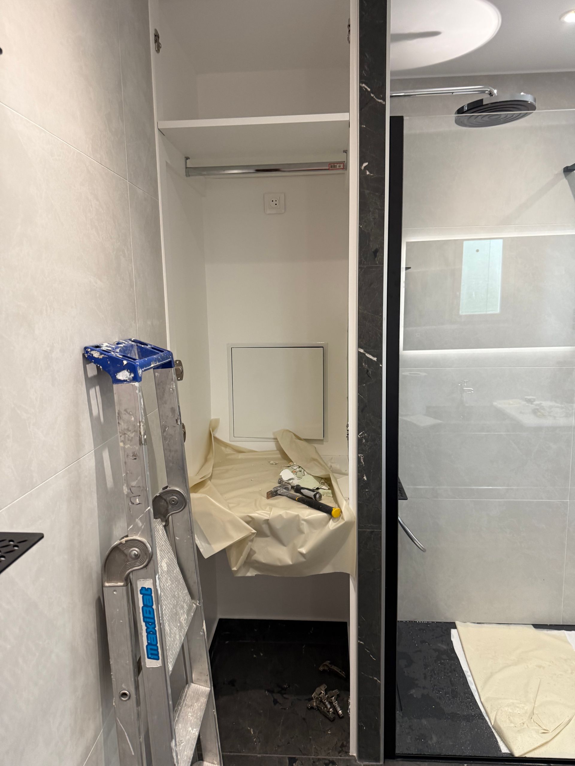 Douche en travaux avec bâches de protection et escabeau