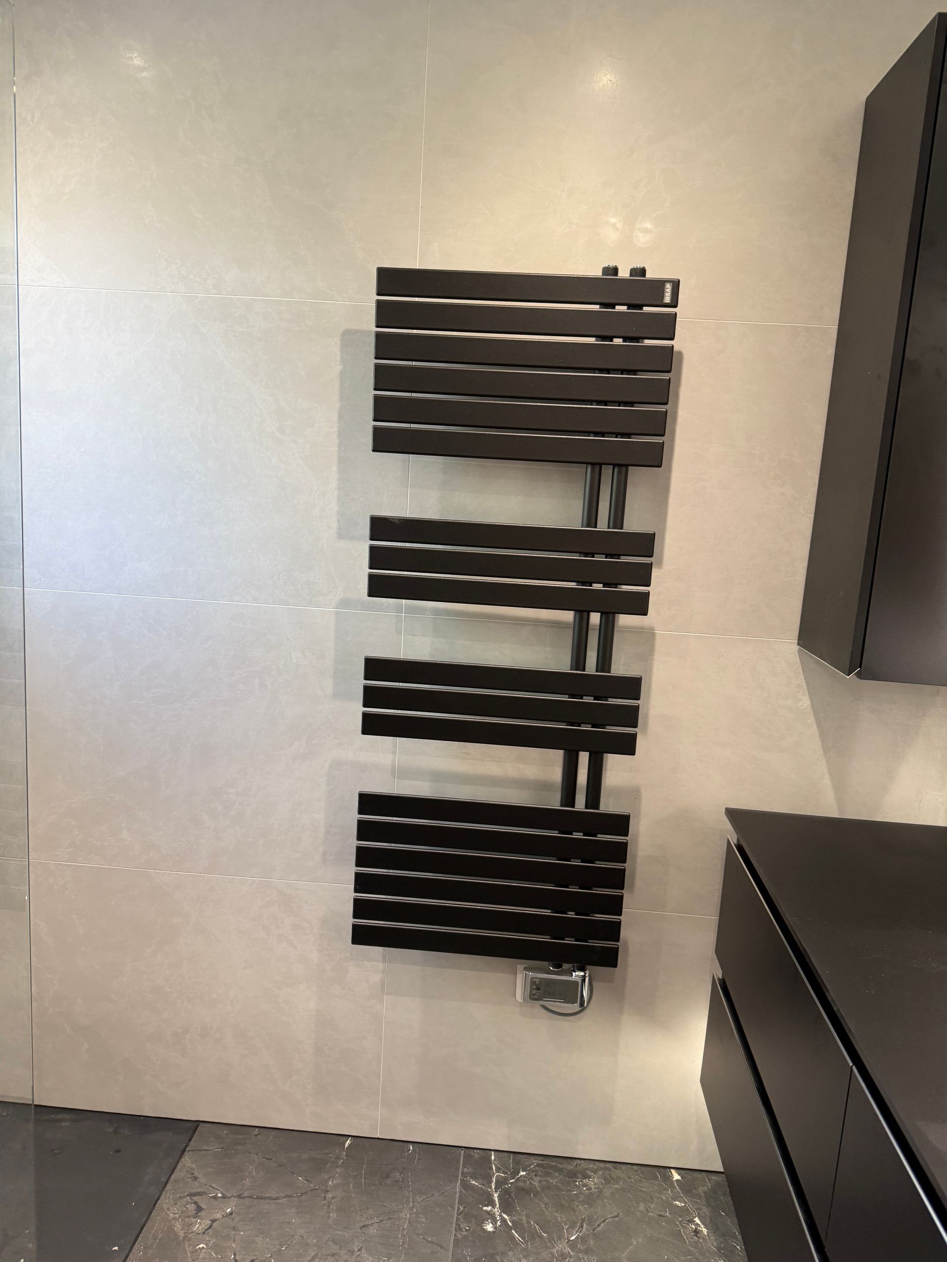 Radiateur sèche-serviettes design noir sur mur clair